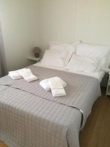 a white bed with two white towels on it at Monte Loureiro-caveira in Melides