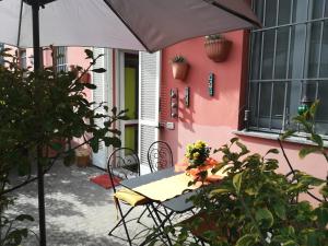 uma mesa com um guarda-chuva em frente a uma casa cor-de-rosa em Milano in Voga em Milão