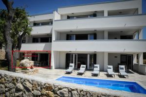 een villa met zwembad voor een gebouw bij Apartments Novak in Rab