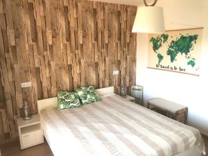 1 dormitorio con 1 cama y pared de madera en Beachside Apartment en Szántód