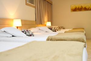 a group of three beds in a hotel room at Hotel Fazenda Pirâmides in Atibaia