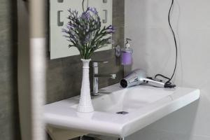 a white sink with a vase of flowers on it at e-stay Hanthana Kandy in Kandy