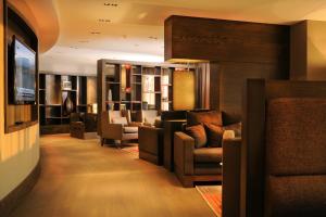 a lobby with a waiting room with chairs and a television at Surmeli Istanbul Hotel in Istanbul