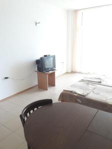 sala de estar con cama y TV en Global Ville Apartcomplex, en Sunny Beach