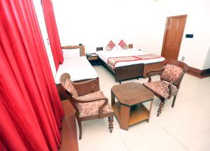 a room with a bed and a table and chairs at YMCA SEACOM INN in Kolkata