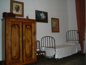 een slaapkamer met een bed, een dressoir en 2 stoelen bij B&B di Charme Camelie in Riposto