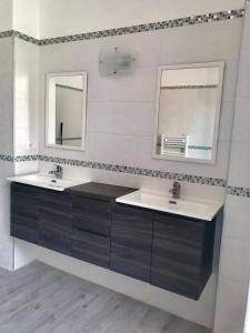 a bathroom with two sinks and two mirrors at Roof Top 19 in Ventimiglia