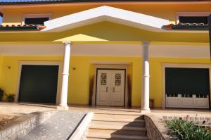 une maison jaune avec des colonnes blanches dans l'établissement O cantar dos passarinhos, à Fátima