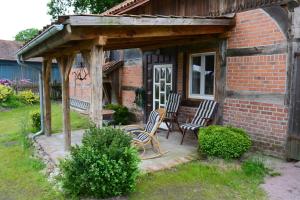 un porche de una casa de ladrillo con mecedoras en Thölkes Hus, en Bötersen