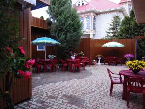 a patio with tables and chairs and umbrellas at Mini Hotel Уютный дворик in Odesa