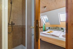 ein kleines Schlafzimmer mit einem Bett und einer Dusche in der Unterkunft Penzion Via Mara in Liptovský Mikuláš