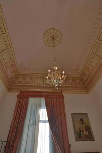 un plafond avec un lustre et une fenêtre avec un rideau dans l'établissement B&B di Charme Camelie, à Riposto