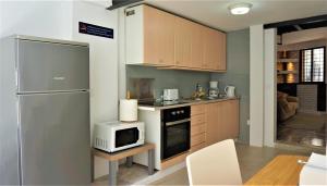 a kitchen with a microwave and a refrigerator at Casa Borguny - House in the centre of Palma in Palma de Mallorca