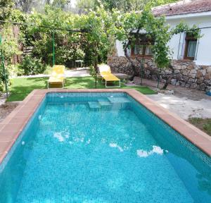 a swimming pool with two chairs and a house at Olmedilla in Olmeda de las Fuentes