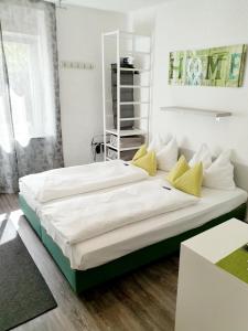 een slaapkamer met 2 bedden en gele kussens bij Hotel Deutschherrenhof in Trier