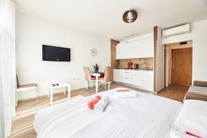 - une chambre blanche avec un lit blanc et une cuisine dans l'établissement Studio apartman Lena, à Umag