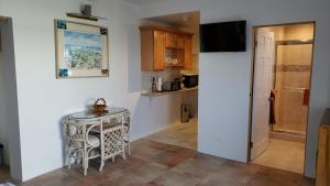 a small kitchen with a table and a refrigerator at Pauls Oceanview with Amazing Sunsets in Hog Bay