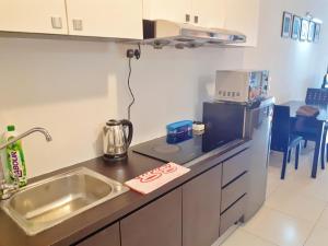 新山的住宿－巴余海濱度假村（一室公寓民宿），一间带水槽和微波炉的小厨房