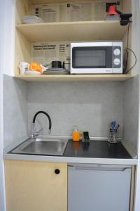 eine Küche mit einer Spüle und einer Mikrowelle in der Unterkunft Cosy Apartment in the Center in Tbilisi City