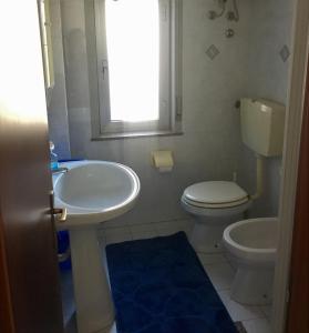 a bathroom with a sink and a toilet and a window at Casa Vacanza “La Mantinera” in Falcone