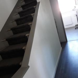 a stairway with a white wall and black stairs at Appartement en duplex au 3ième étage sans ascenseur in Hyères