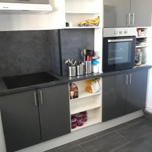 cocina con armarios negros y microondas en Appartement en duplex au 3ième étage sans ascenseur, en Hyères