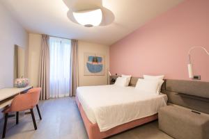 a bedroom with a bed and a desk and a chair at Le Funi Hotel in Bergamo