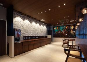 a restaurant with chairs and a bar with at One's Hotel Fukuoka in Fukuoka