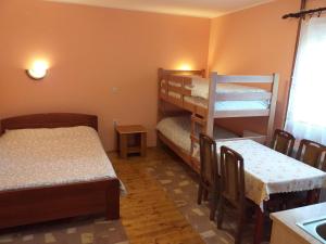 a room with two bunk beds and a table and chairs at Apartments Vukomanović in Zlatibor