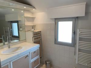 a bathroom with a sink and a mirror at Les pieds dans l'eau accès direct à la plage ! in Granville +21 photos