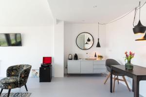 een witte woonkamer met een tafel en stoelen bij Paulus Loot Zandvoort in Zandvoort