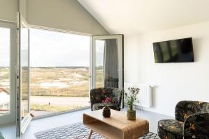 sala de estar con 2 sillas y mesa en Paulus Loot Zandvoort, en Zandvoort