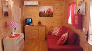 sala de estar con sofá rojo y escritorio en Chalet Lake Lugano, Vienna 18, en Porlezza