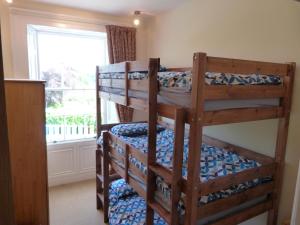 two bunk beds in a room with a window at Carr View Hall Apt3 Grade II Listed in Sleights