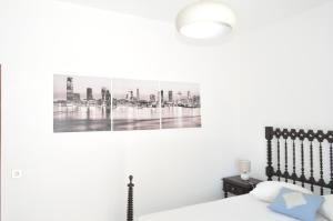 1 dormitorio con 1 cama con una foto en la pared en Apartamento do Mar, en Armação de Pêra