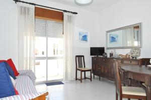 a living room with a dining room table and a desk at Apartamento do Mar in Armação de Pêra