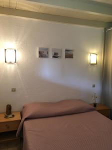 una camera con un letto e due luci sul muro di Lavu Santu a Sainte-Lucie de Porto-Vecchio