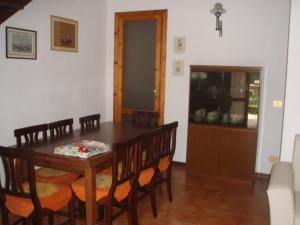 een eetkamer met een houten tafel en stoelen bij VILLA ORATA 8b in Principina a Mare