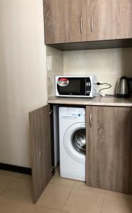 a kitchen with a washing machine and a microwave at Трёхуровневая квартира у моря in Odesa