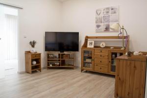 a living room with a flat screen tv and wooden furniture at Apartments Gerda in Vřesina