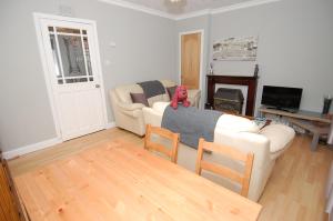 Sala de estar con 2 sofás blancos y TV en Mar Apartment en Stirling