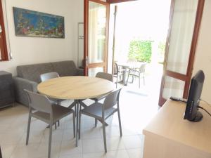 un soggiorno con tavolo, sedie e divano di Villa Agavi 2 a Bibione