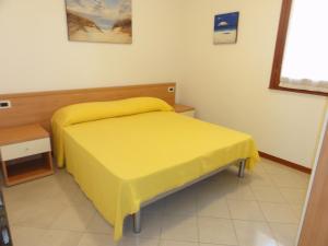 una camera con letto giallo di Villa Agavi 2 a Bibione