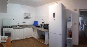 La cuisine est équipée d'un réfrigérateur blanc et d'un évier. dans l'établissement Tenplata, à Tijoco de Abajo