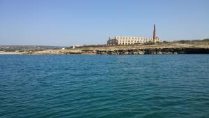 a large body of water with a building in the background at Hotel Le Dune in Sampieri