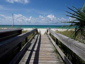 a wooden boardwalk leading to a beach with the ocean at The Catalina in Panama City Beach