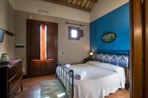 1 dormitorio con 1 cama con pared azul en Agriturismo Don Carlo, en Baglio Rizzo