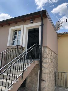 a house with a staircase leading up to a door at Studio apartman Braco in Risika