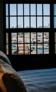 a bedroom with a view of a city from a window at Exmo Hotel by Olivia in Porto