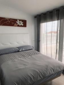 a bedroom with a large bed with a window at Martin Stone Mil Palmeras Beach in La Horadada
